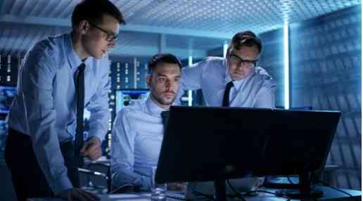 Cybersecurity techs looking at a desktop computer
